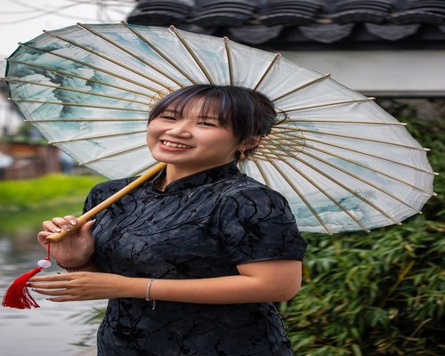 asian woman holding a notebook smiling warmly